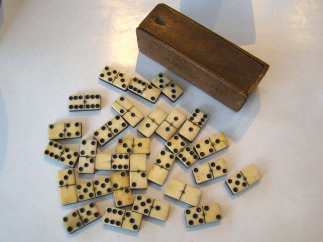 A beautiful set of 19th century bone and ebony dominoes in their original box dated April 27, 1881